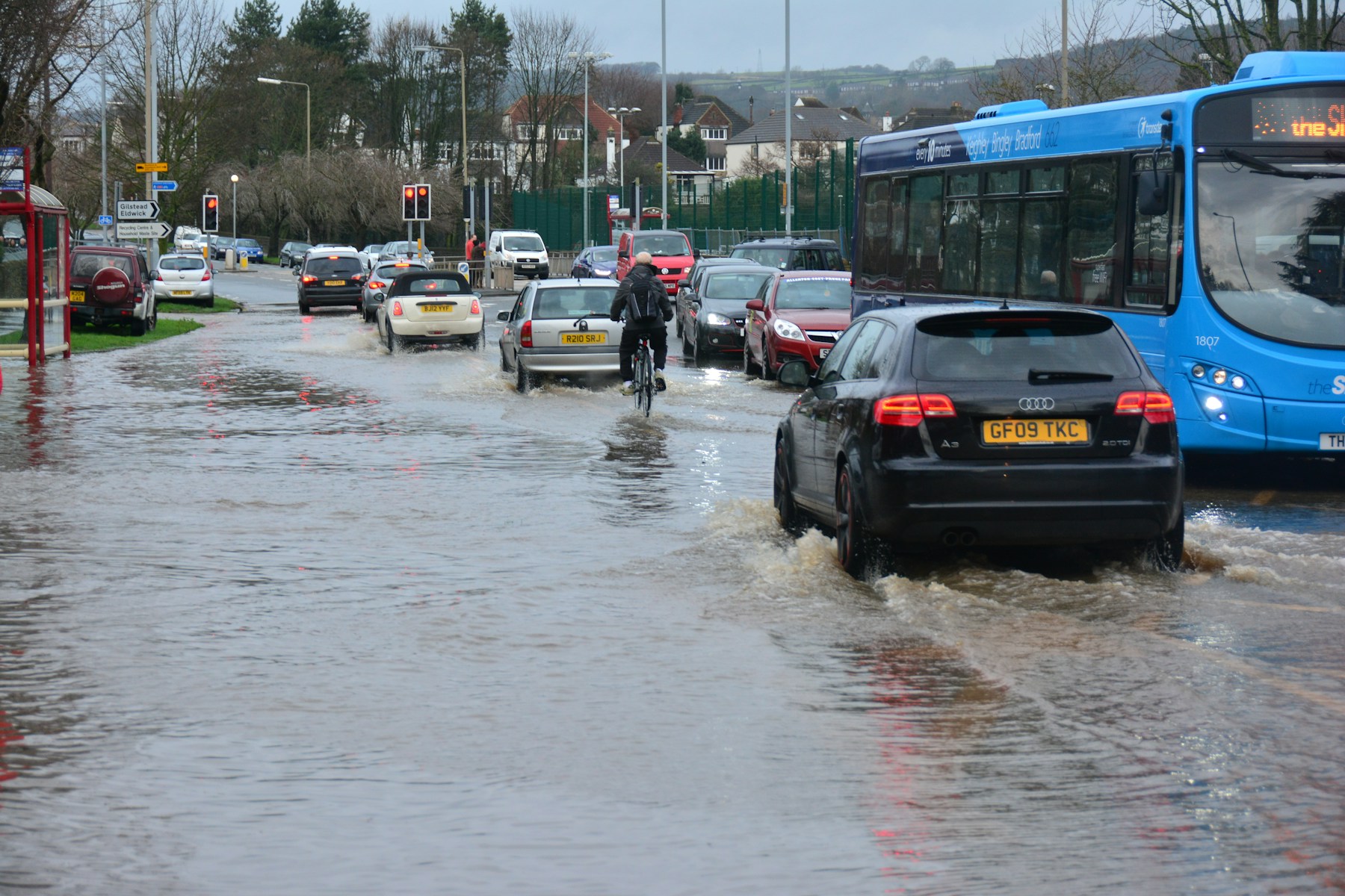 Vehicles driving through a flooded urban street